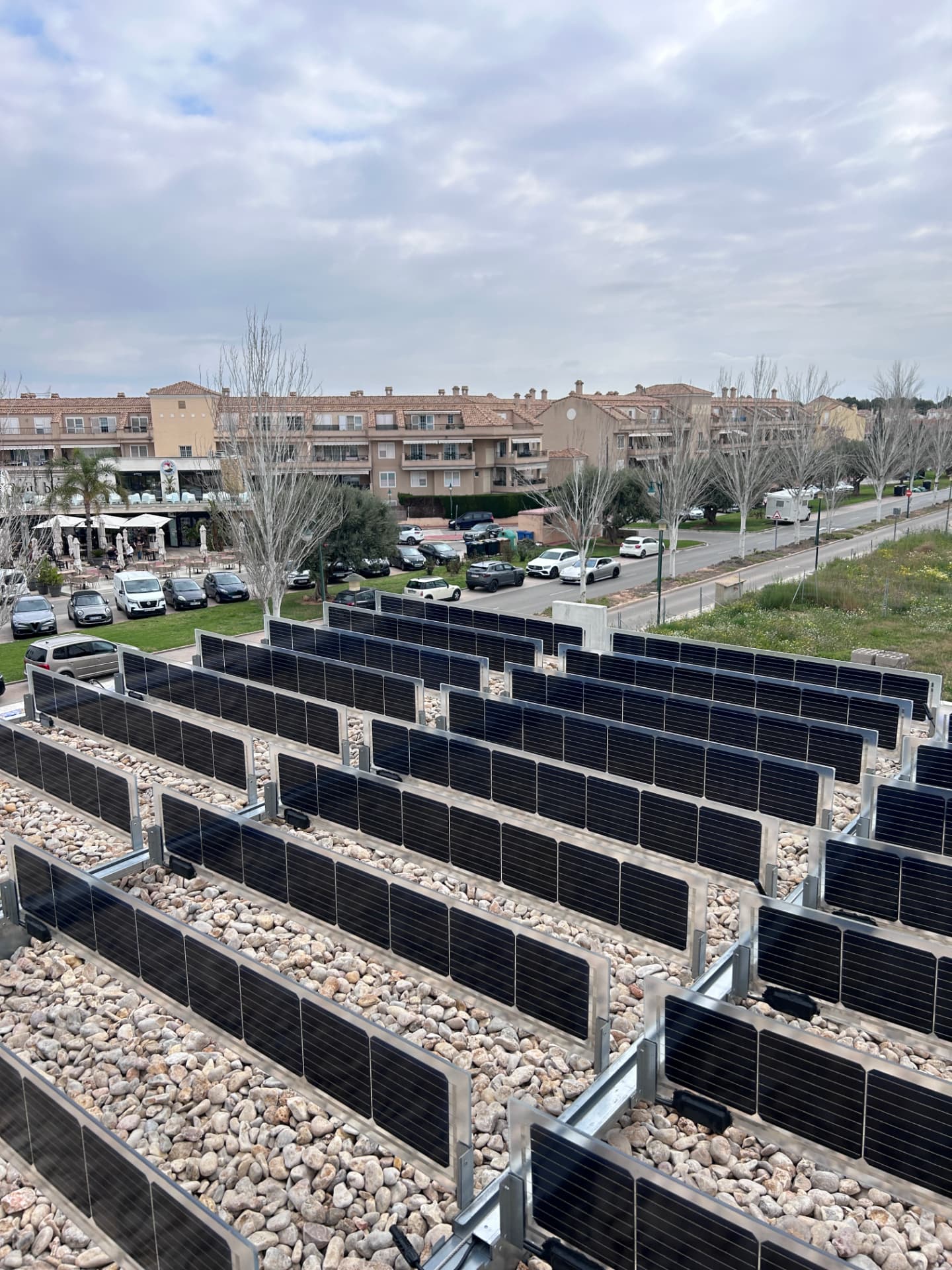 Small solar installation with vertical bifacial panels on a gravel flat roof in Spain